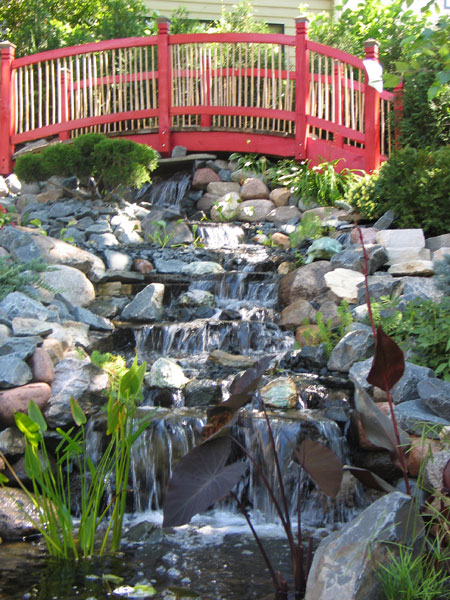Garden waterfall with red bridge Superior Stone Distributors Naples Southwest Florida Natural Stone Distributors